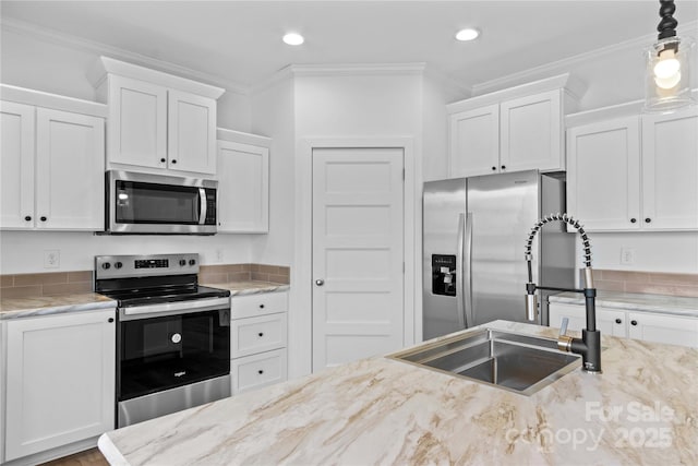 kitchen with appliances with stainless steel finishes, sink, and white cabinets