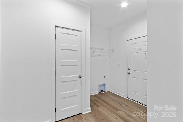 clothes washing area featuring light wood-type flooring, crown molding, and electric dryer hookup