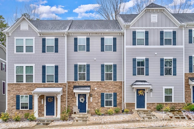 multi unit property with stone siding, a shingled roof, and board and batten siding