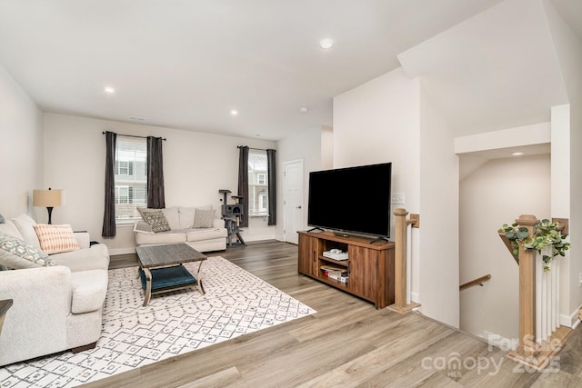 living room featuring light wood-style floors, baseboards, and recessed lighting