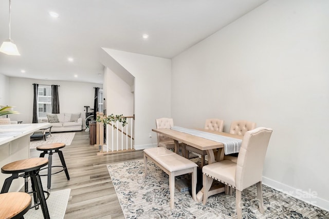 dining room featuring baseboards, light wood-type flooring, and recessed lighting