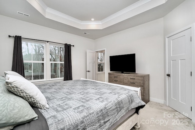 bedroom with a raised ceiling, light colored carpet, visible vents, and baseboards