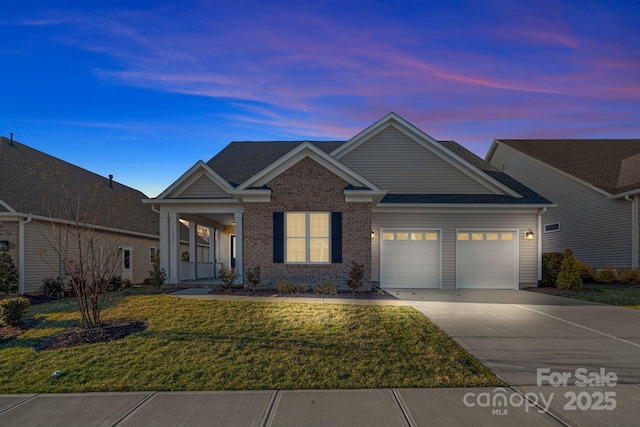 view of front facade with a garage, a front lawn, concrete driveway, and brick siding