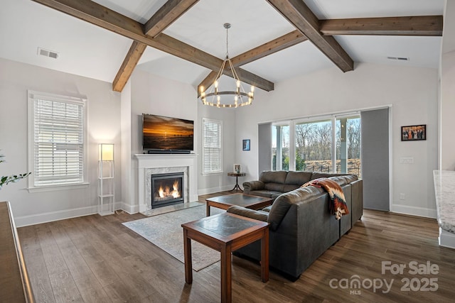 living area with lofted ceiling with beams, dark wood-type flooring, a fireplace, and visible vents