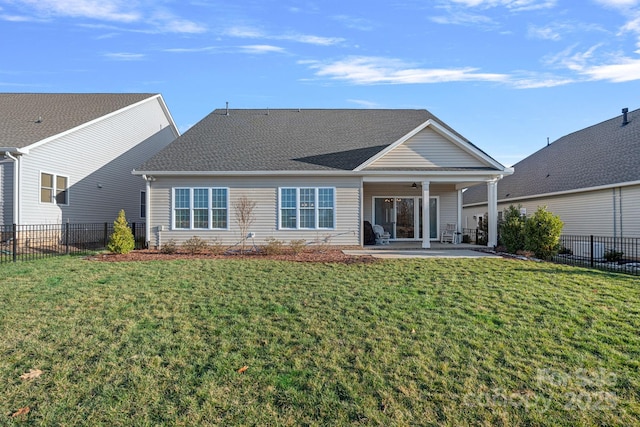 rear view of property with a patio, a yard, and fence