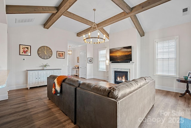 living area featuring a healthy amount of sunlight, a fireplace, visible vents, and wood finished floors