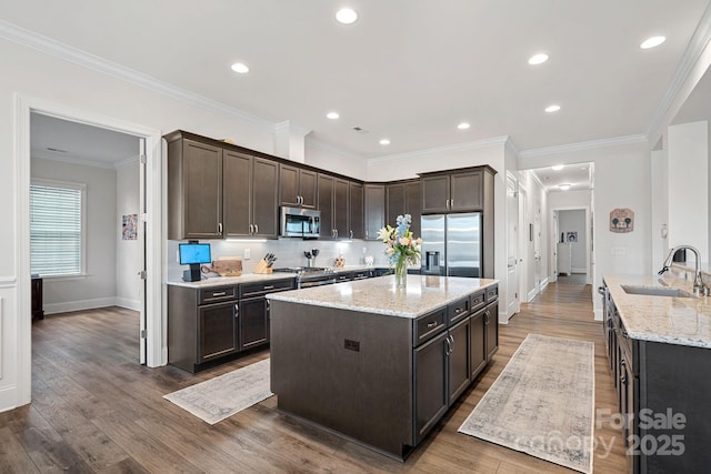 kitchen with stainless steel appliances, dark brown cabinets, and a sink