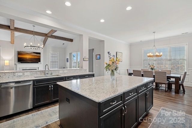 kitchen featuring a sink, an inviting chandelier, a kitchen island, and dishwasher