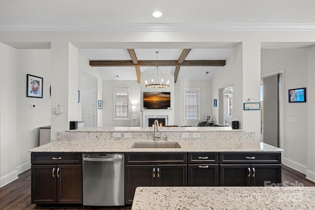 kitchen with decorative light fixtures, stainless steel dishwasher, open floor plan, a sink, and a warm lit fireplace