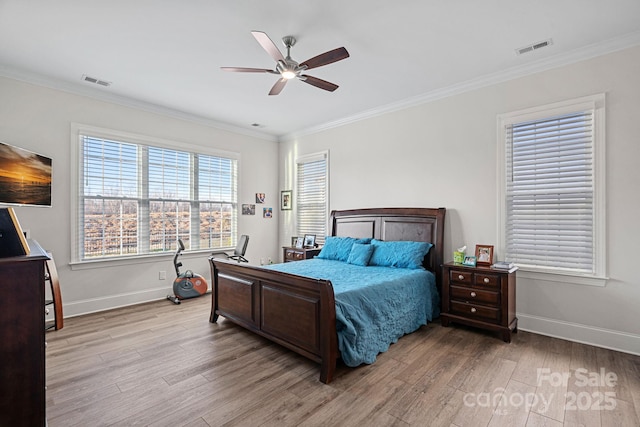 bedroom featuring light wood-style floors, visible vents, and crown molding