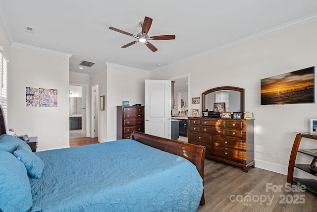 bedroom featuring visible vents, connected bathroom, baseboards, and wood finished floors