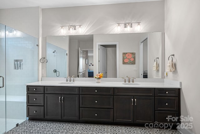 bathroom featuring double vanity, a stall shower, and a sink