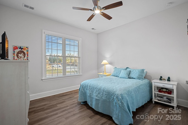 bedroom featuring baseboards, visible vents, dark wood finished floors, and a ceiling fan