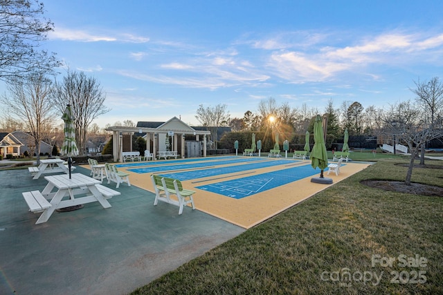 view of home's community featuring shuffleboard and a yard