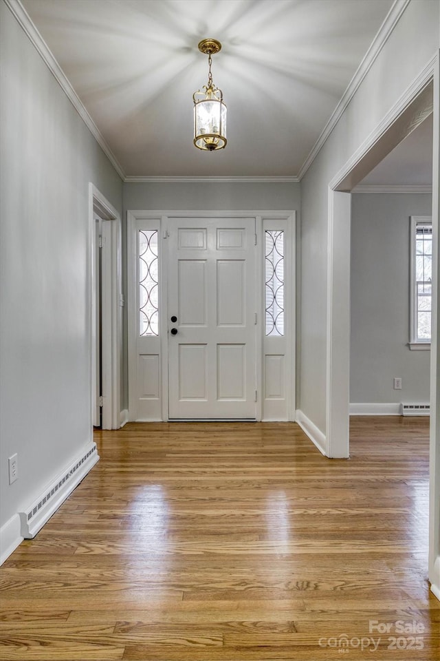 entrance foyer featuring light wood-style floors, a baseboard radiator, ornamental molding, and baseboard heating