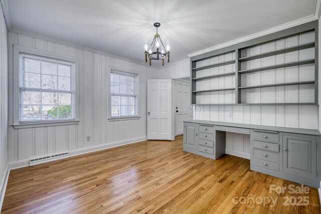 unfurnished office featuring visible vents, built in desk, light wood-style flooring, and crown molding