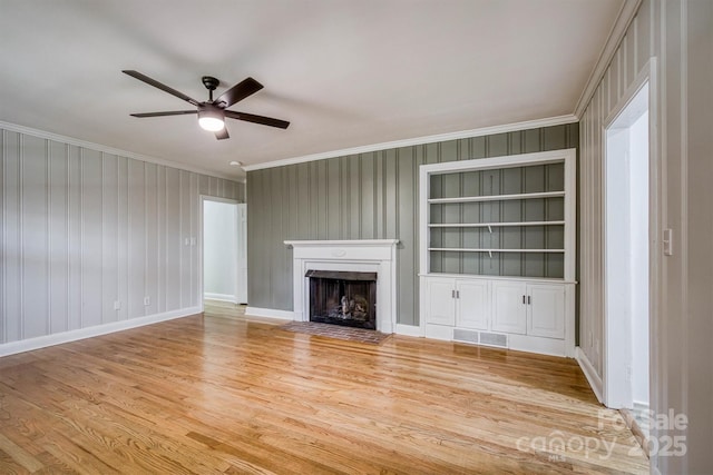 unfurnished living room with visible vents, ceiling fan, crown molding, light wood-type flooring, and a fireplace