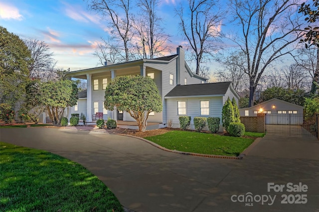 view of front of property with a garage, a chimney, and a front lawn