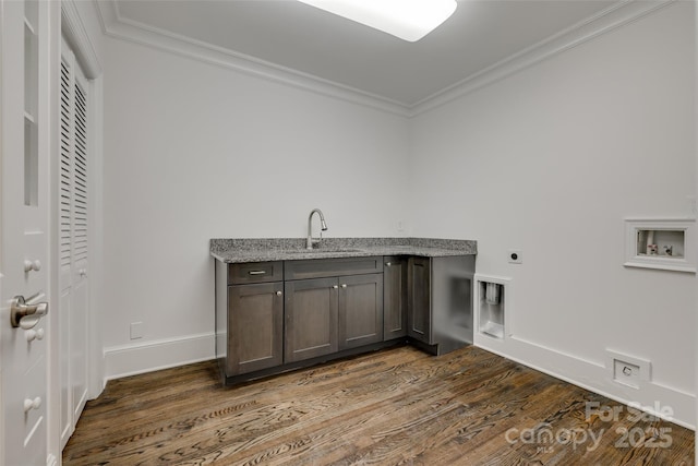 washroom with ornamental molding, a sink, cabinet space, and hookup for a washing machine