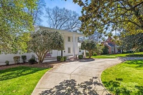 view of front facade with fence, a front lawn, and concrete driveway