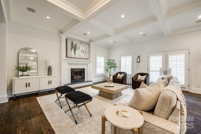 living area featuring dark wood-type flooring, coffered ceiling, beam ceiling, and a tile fireplace