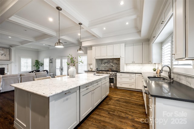 kitchen featuring a sink, open floor plan, a kitchen island, and white cabinetry