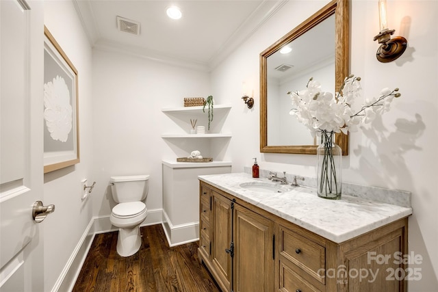 bathroom with visible vents, crown molding, vanity, and wood finished floors