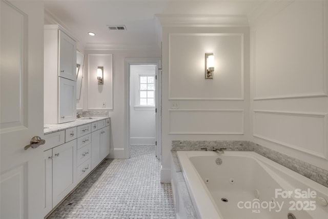 full bath with double vanity, visible vents, ornamental molding, baseboards, and a tub with jets