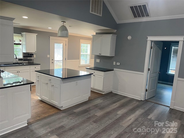 kitchen with dark countertops, visible vents, a sink, and white cabinetry