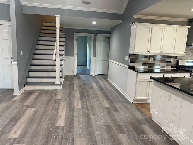 kitchen featuring stainless steel range oven, ornamental molding, dark wood-style flooring, and white cabinetry