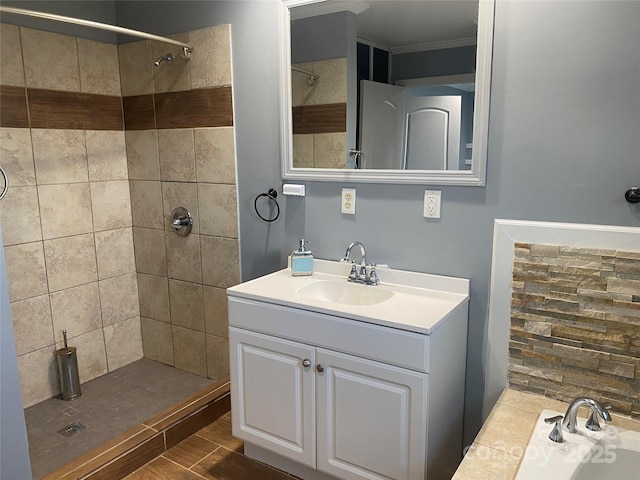 bathroom featuring a garden tub, crown molding, tiled shower, and vanity