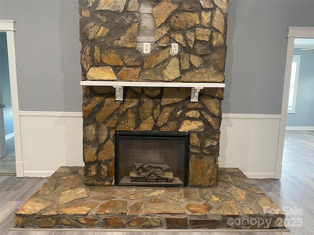 interior details featuring a fireplace, wood finished floors, and baseboards