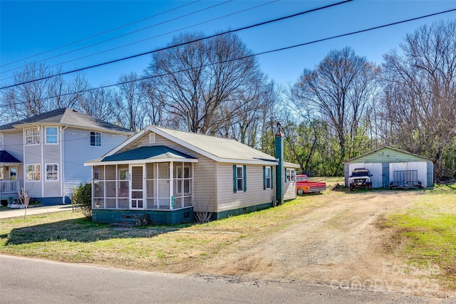 view of front of home with crawl space, a sunroom, and an outbuilding