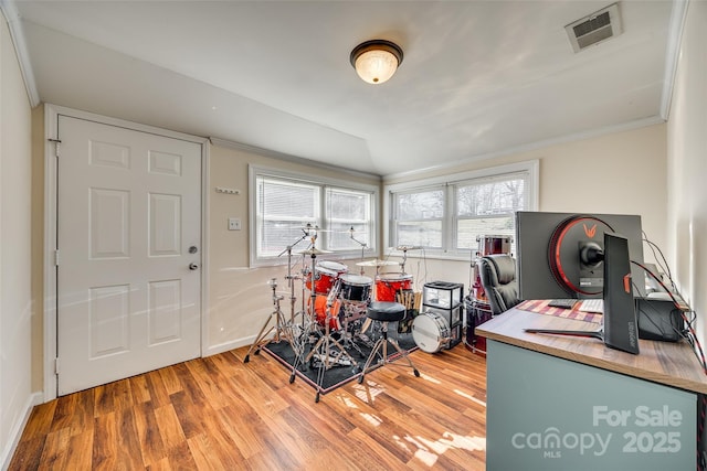 playroom with crown molding, visible vents, vaulted ceiling, and wood finished floors