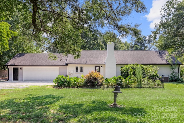 ranch-style home with a chimney, a front yard, fence, a garage, and driveway