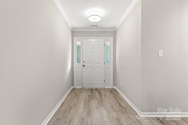 doorway to outside featuring crown molding, light wood finished floors, and baseboards