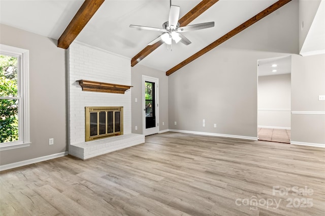 unfurnished living room with a brick fireplace, wood finished floors, beam ceiling, and baseboards