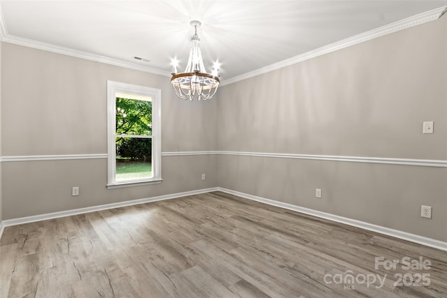 unfurnished room featuring wood finished floors, visible vents, baseboards, ornamental molding, and an inviting chandelier