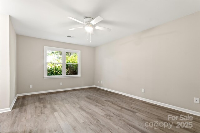 empty room with visible vents, baseboards, and wood finished floors