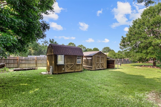 view of yard with an outbuilding, a fenced backyard, and a storage unit