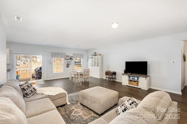 living area featuring wood finished floors, visible vents, and baseboards