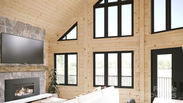 unfurnished living room with a fireplace, wood ceiling, and wood walls