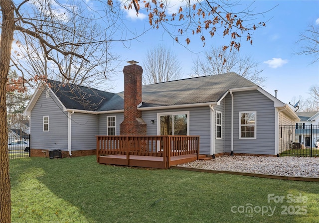 rear view of property with a wooden deck, fence, and a yard