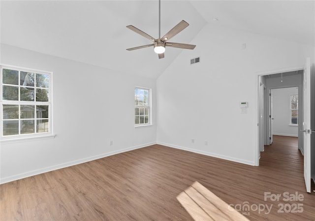 spare room with visible vents, attic access, ceiling fan, wood finished floors, and baseboards