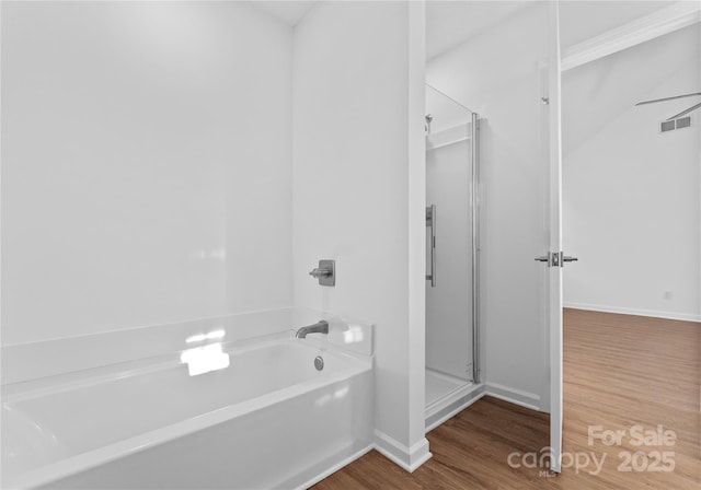 full bathroom with visible vents, a shower stall, wood finished floors, baseboards, and a bath