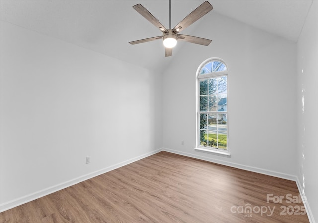 unfurnished room featuring baseboards, vaulted ceiling, a wealth of natural light, and wood finished floors