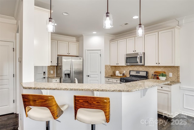 kitchen featuring stainless steel appliances, decorative light fixtures, light stone countertops, and a kitchen breakfast bar