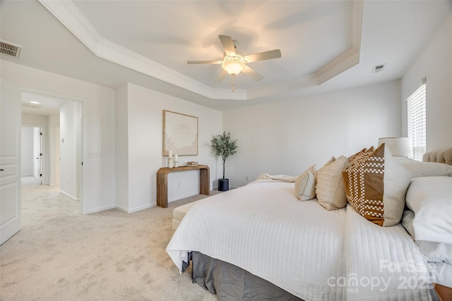 bedroom featuring a raised ceiling, light carpet, visible vents, and baseboards