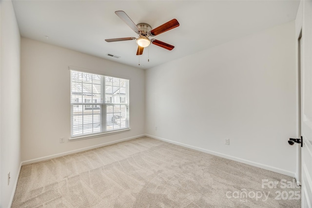 unfurnished room featuring baseboards, visible vents, a ceiling fan, and light colored carpet