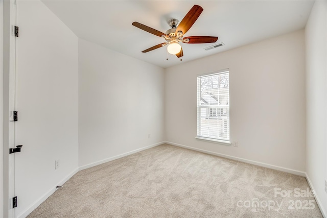 spare room with visible vents, ceiling fan, light carpet, and baseboards